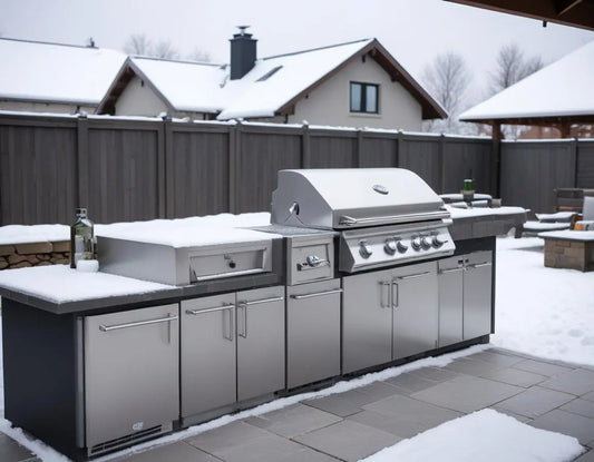 Professional photograph of a premium stainless steel outdoor kitchen with built-in grill being winterized - showing high-quality fitted covers being placed over components, with light snow in the background and winterization supplies nearby